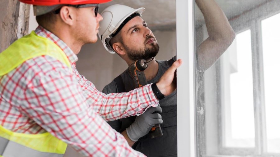 operai che posano una finestra